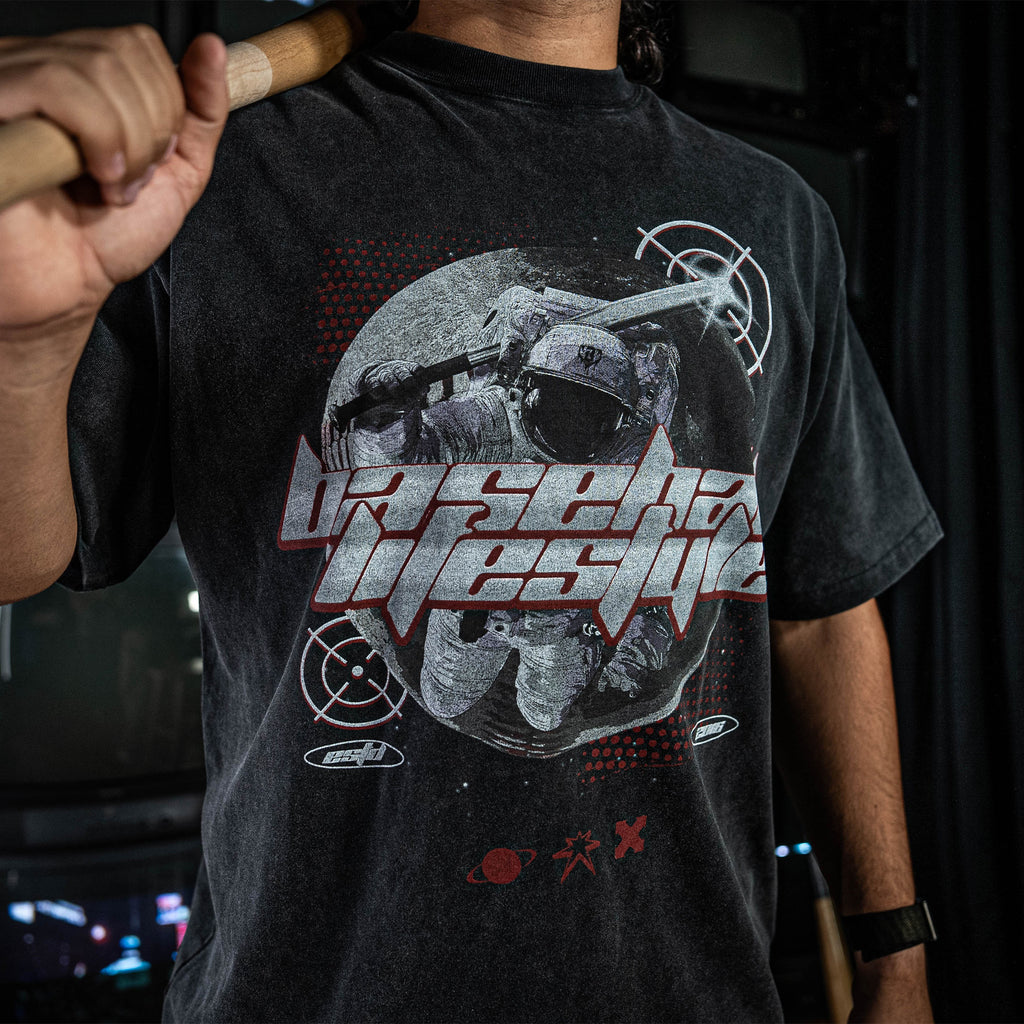 Person wearing a grey t-shirt with graphic design and 'Baseball Lifestyle' text, holding a bat