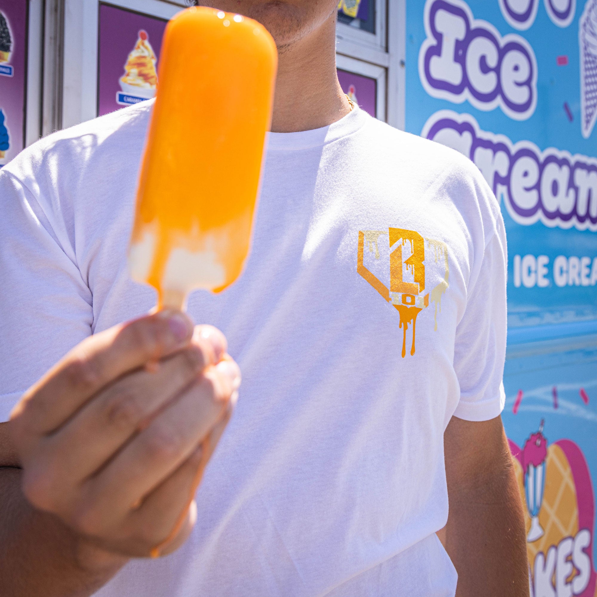 Adult model wearing white Ice Cream Creamsicle graphic tee