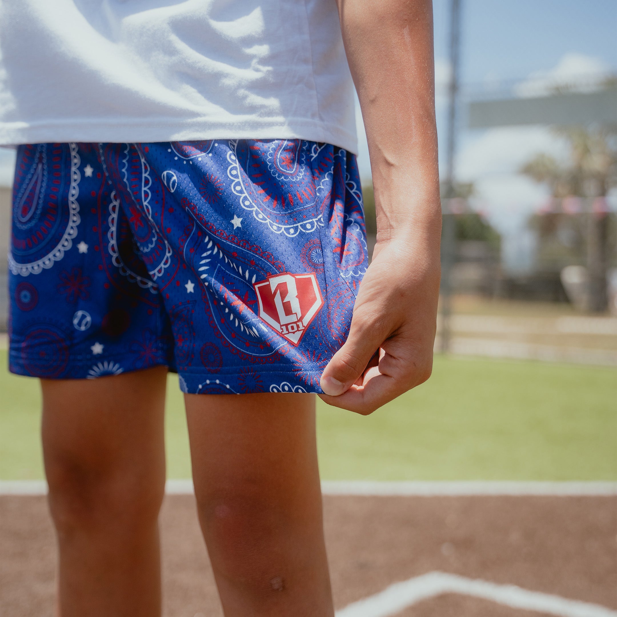 Youth model wearing blue Paisley Liberty youth shorts