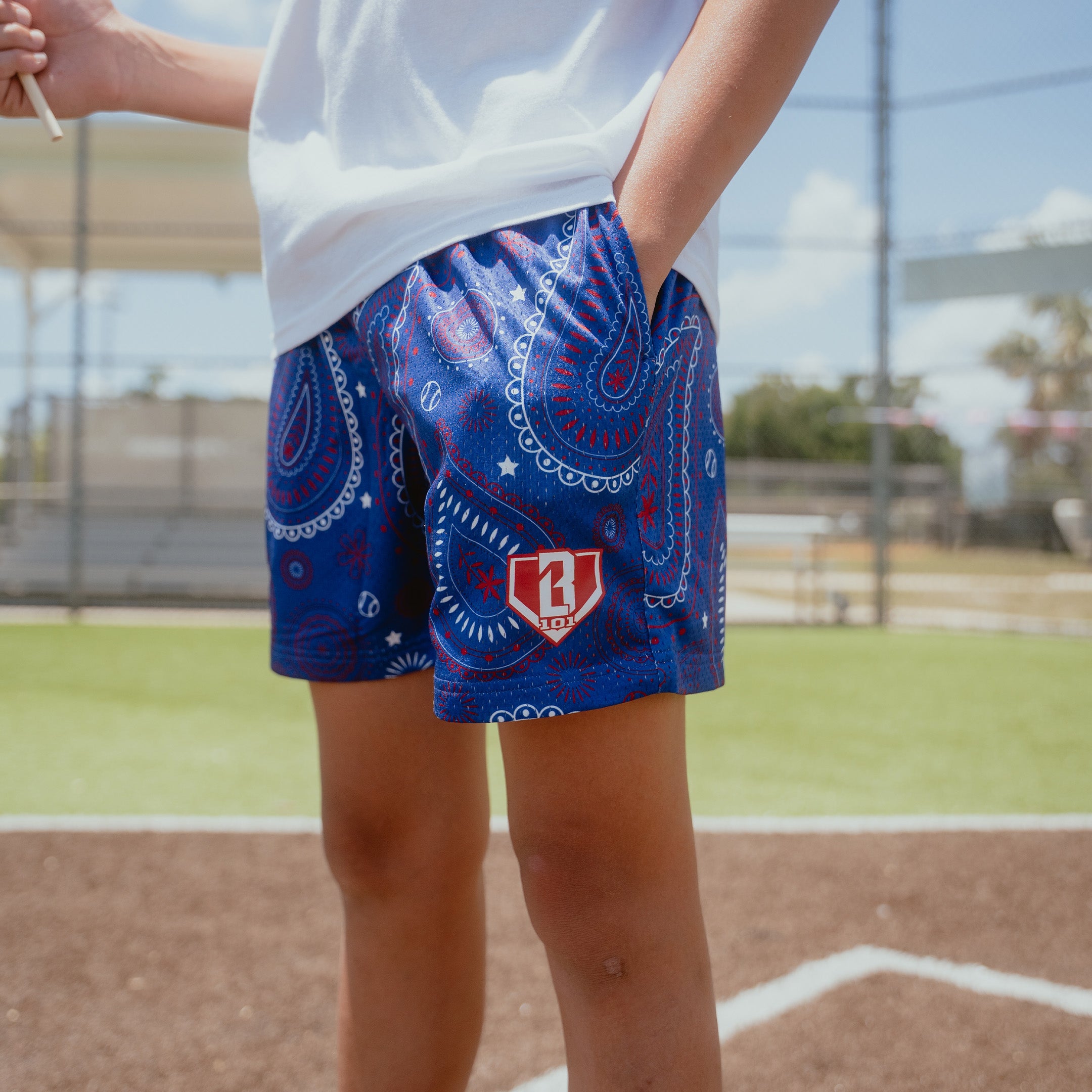 Youth model wearing blue Paisley Liberty youth shorts