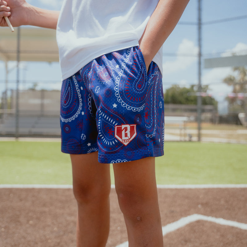 Youth model wearing blue Paisley Liberty youth shorts