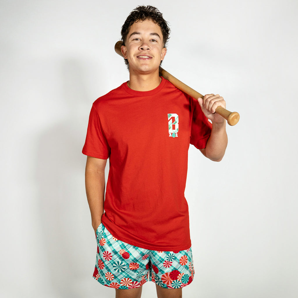 Adult model wearing red graphic tee with "Peppermint Plaid" design