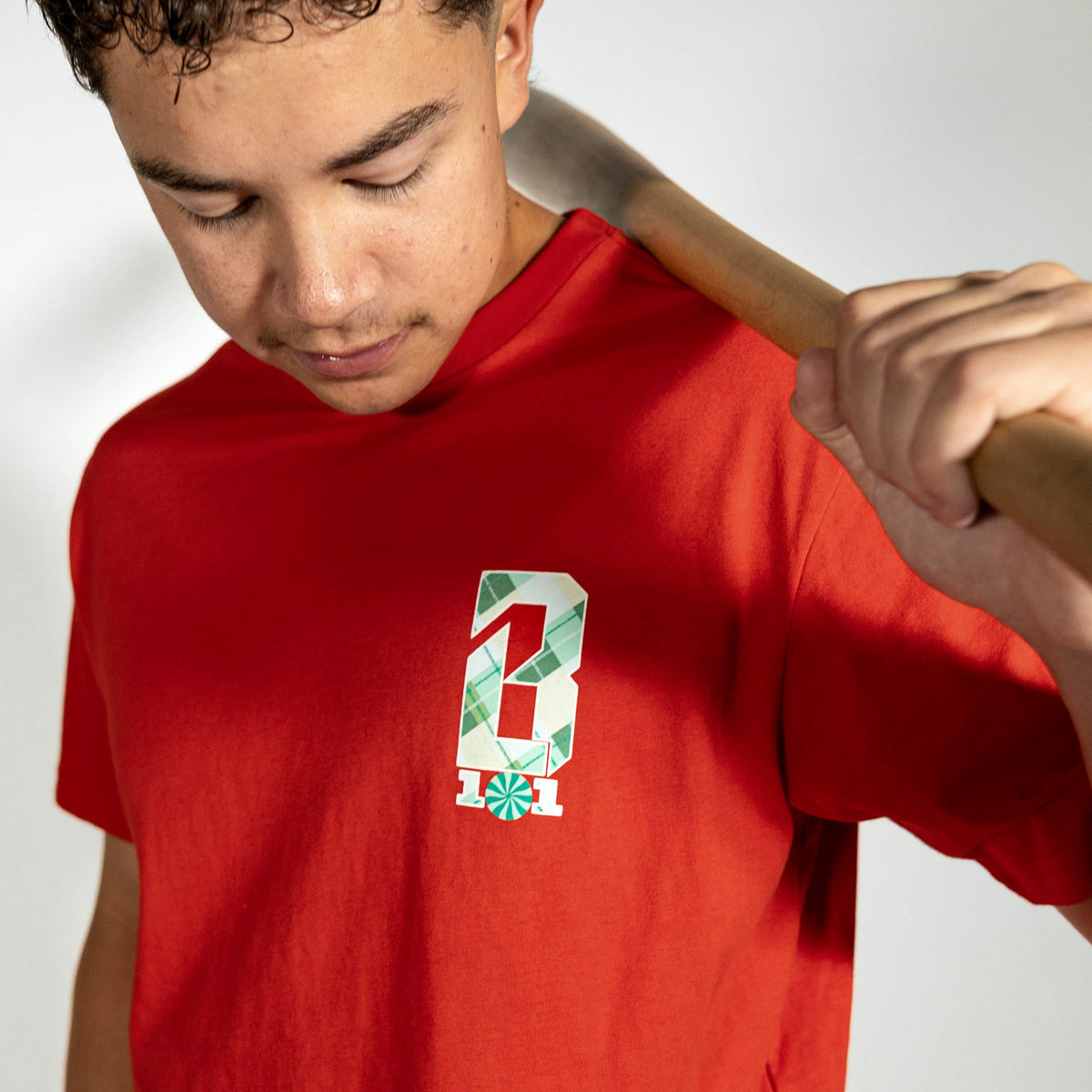 Adult model wearing red graphic tee with "Peppermint Plaid" design