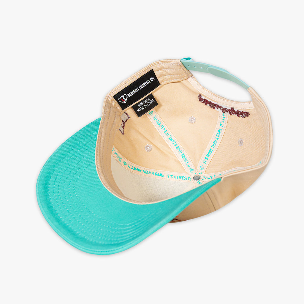 Beige and teal cap with a brand label on a white background