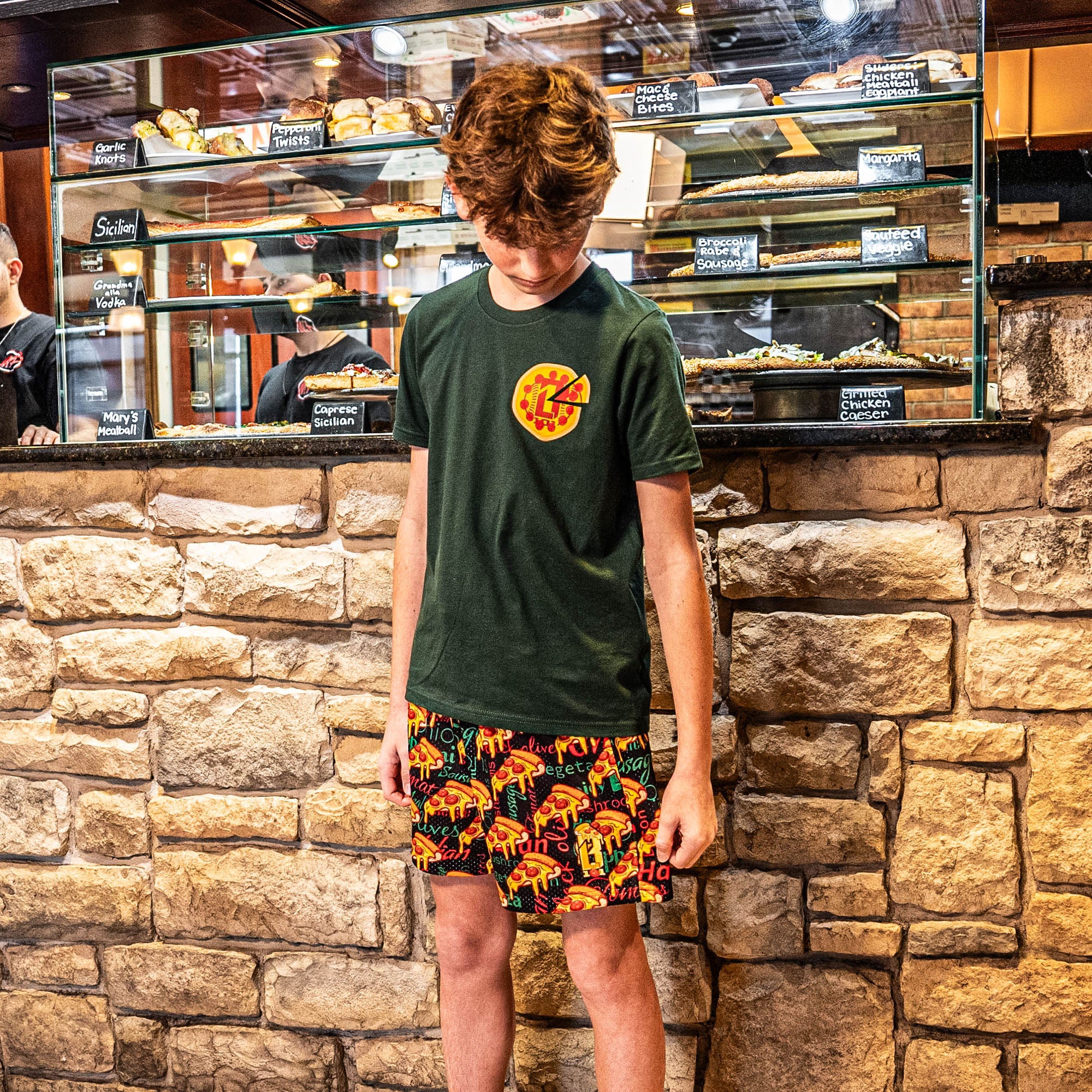 Youth model wearing youth graphic tee with “Pizza Delivery” design
