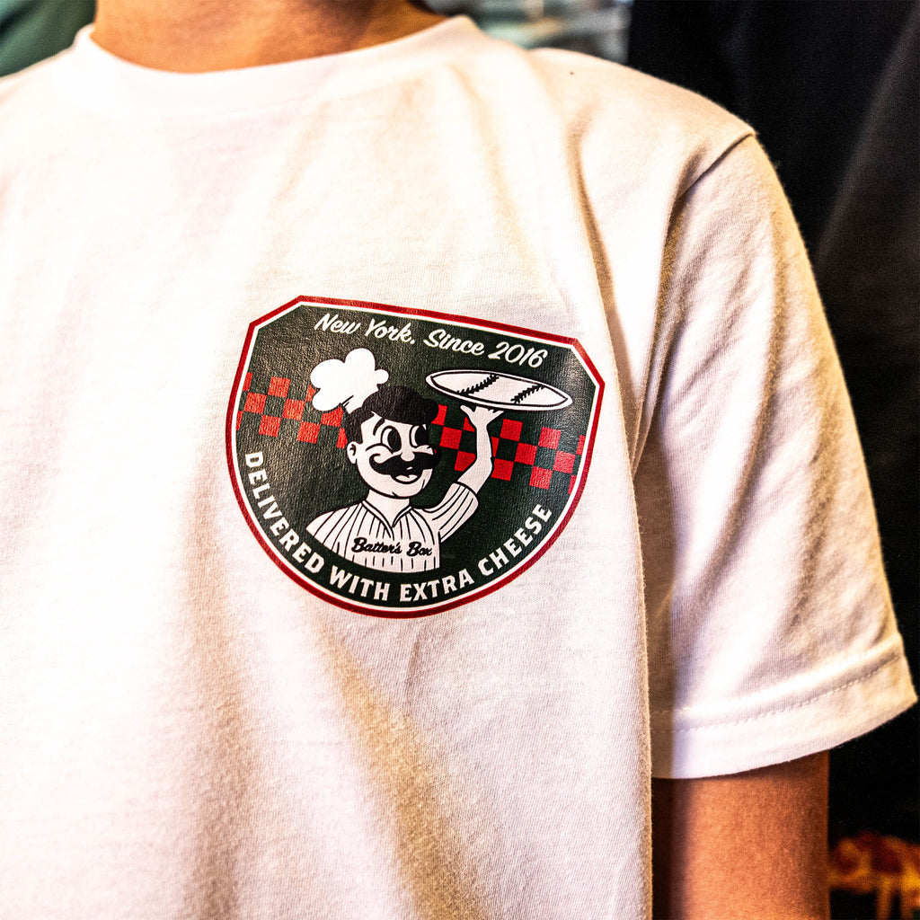 Adult model wearing graphic tee with “Pizza Shop” design