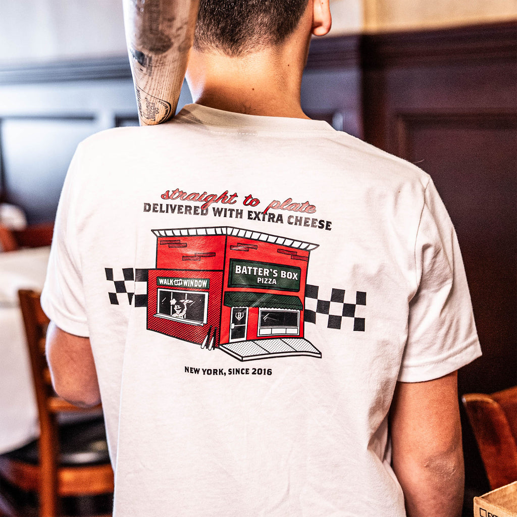 Adult model wearing graphic tee with “Pizza Shop” design
