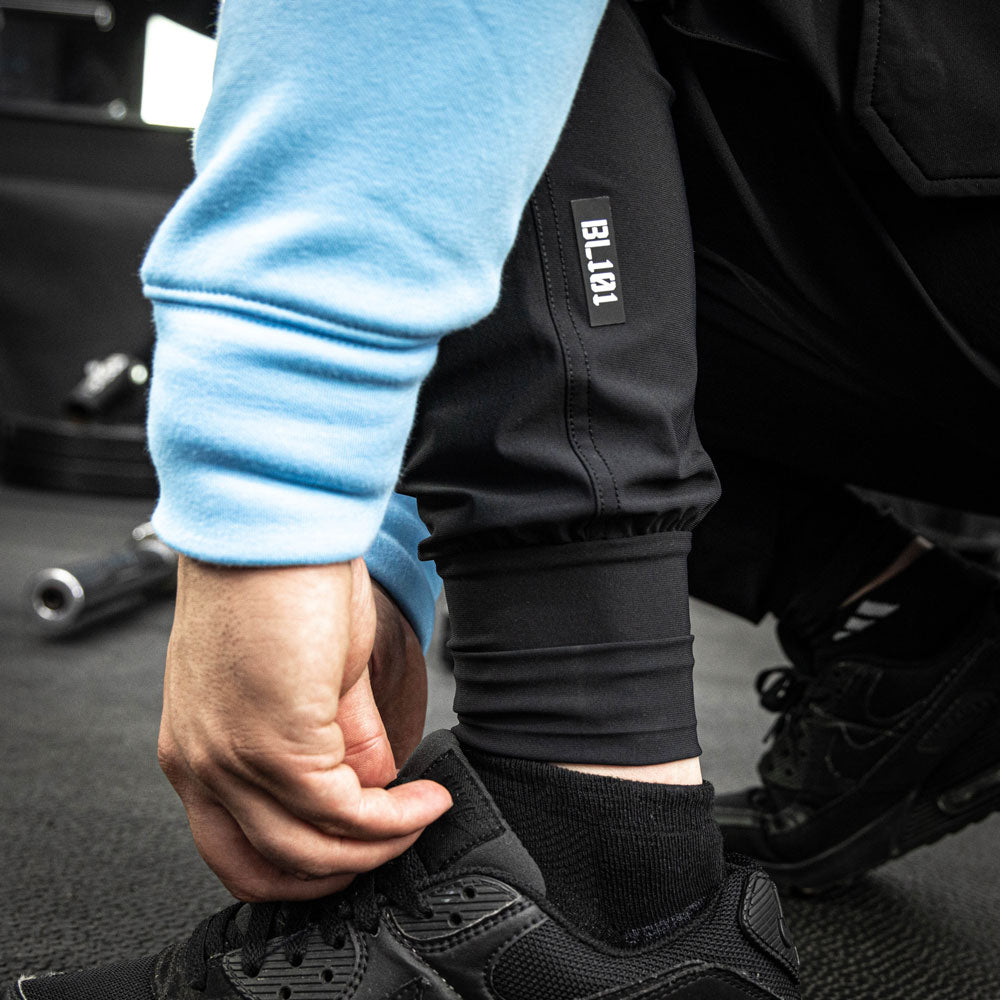 Adult model wearing black Pro Series Long Cuff Cargo Performance joggers