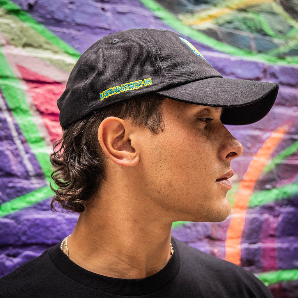 Person wearing a black cap with a blue and yellow Baseball Lifestyle 101 logo