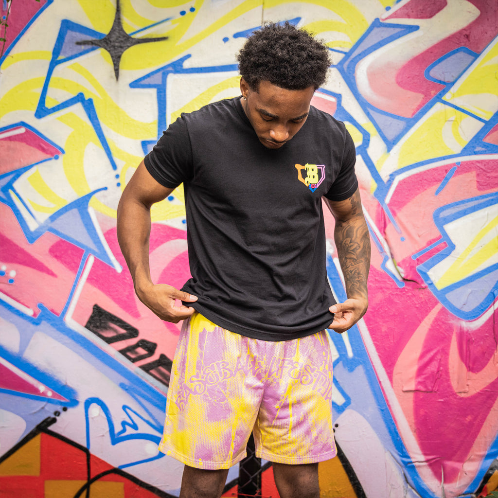 Adult model wearing pink and yellow Retro Graffiti shorts