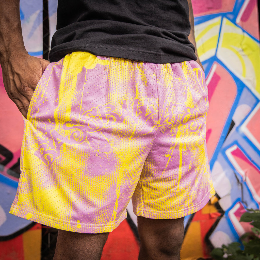 Adult model wearing pink and yellow Retro Graffiti shorts