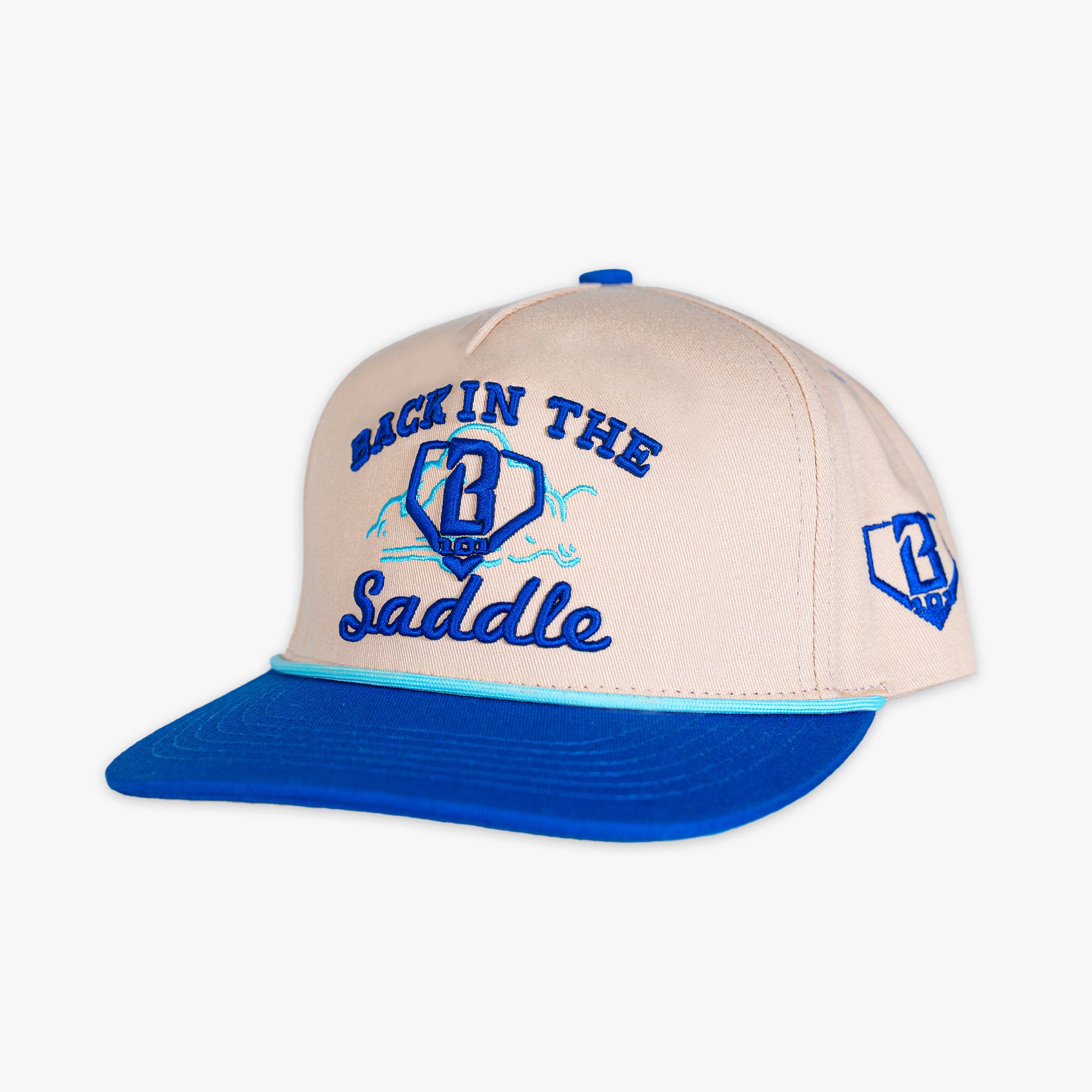 Beige and blue cap with 'Back in the Saddle' text on a white background