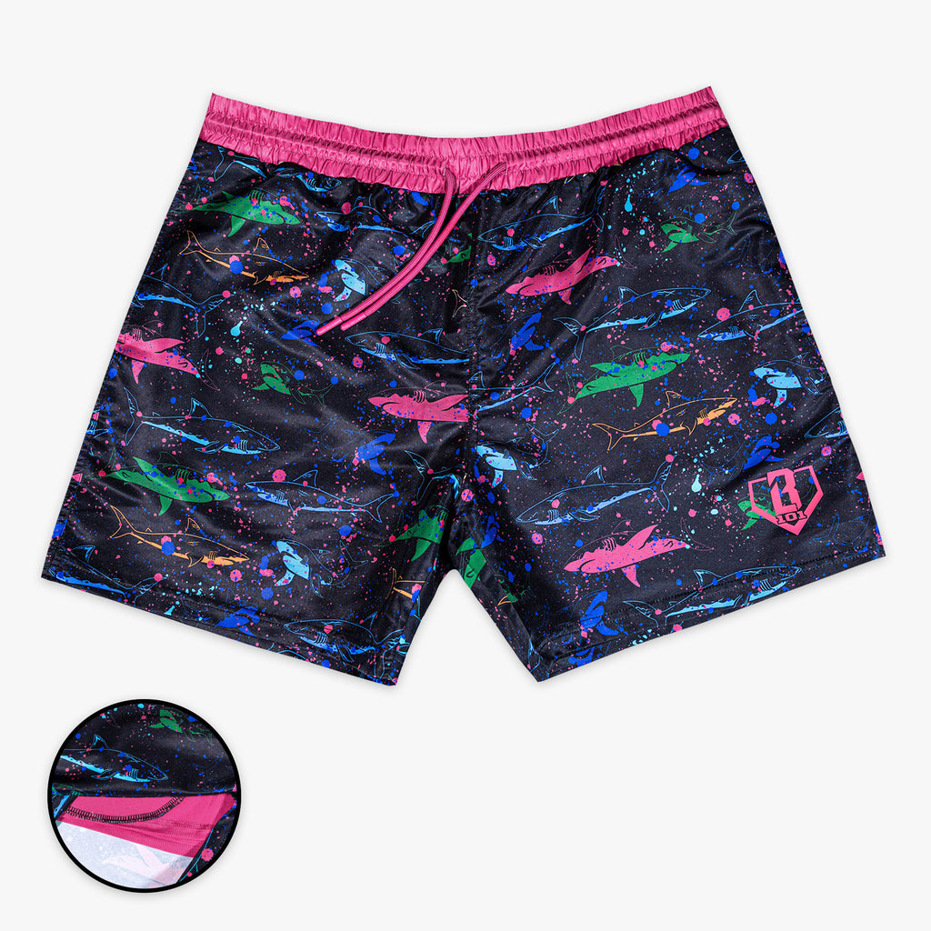 Front view of BL101 black swim shorts with a multicolor neon shark and paint splatter print, featuring a pink waistband and drawstring, with a liner inset detail.
