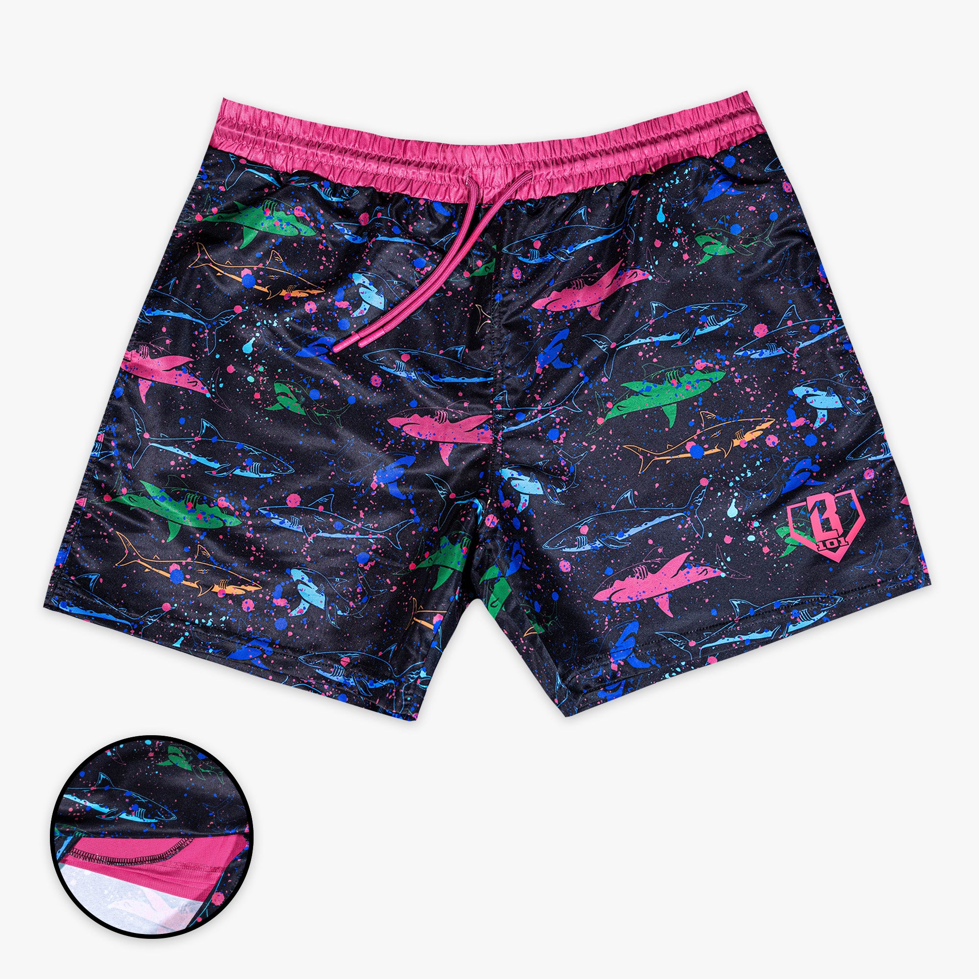 Front view of BL101 black swim shorts with a multicolor neon shark and paint splatter print, featuring a pink waistband and drawstring, with a liner inset detail.