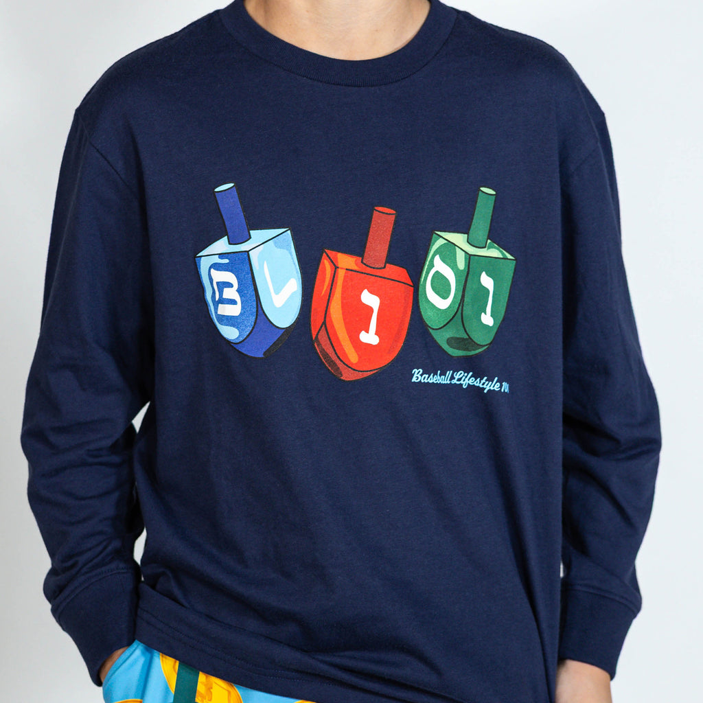 Youth model wearing navy youth graphic tee with "Spin & Swing Long Sleeve" design