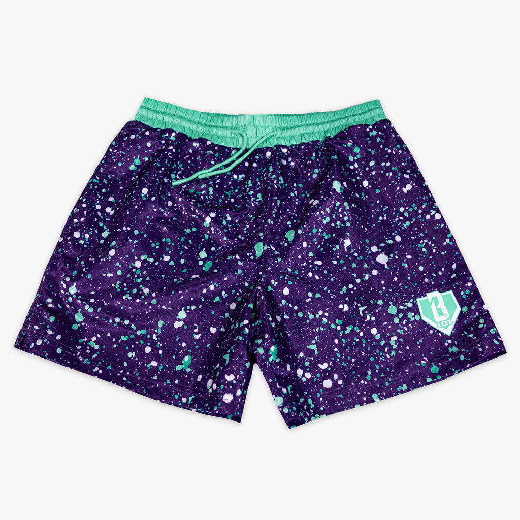 Back flat lay of BL101 purple splatter swim trunks showing the cargo pocket and teal waistband.