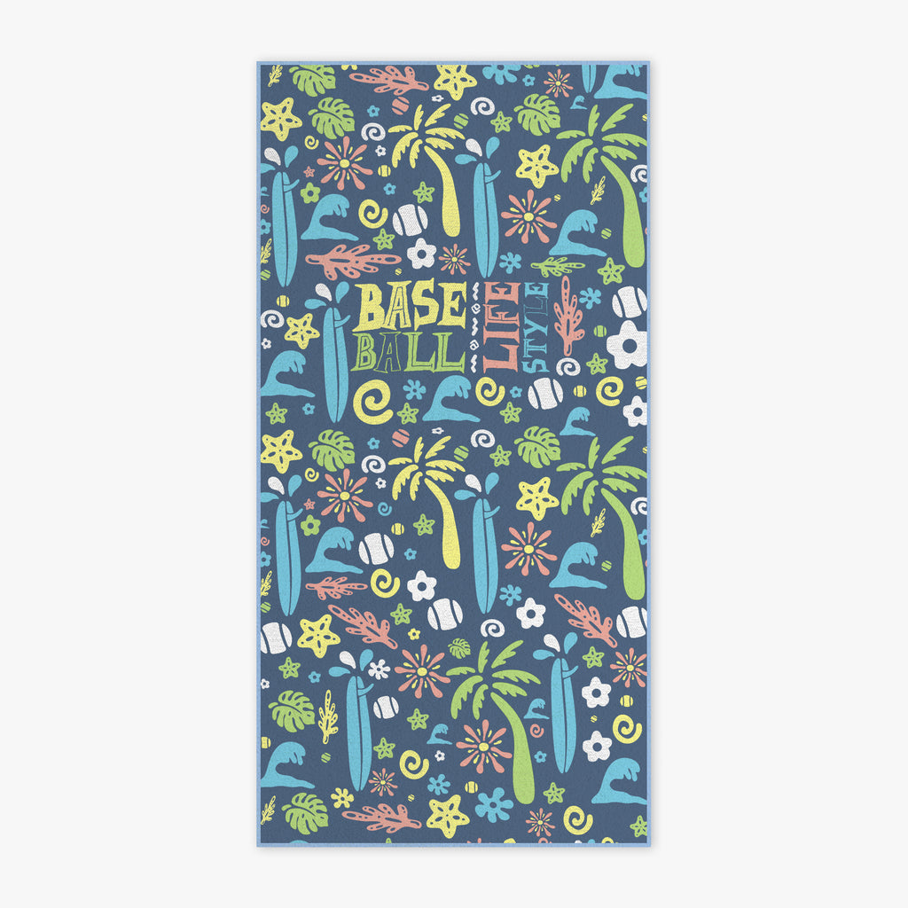 A rectangular beach towel featuring a colorful tropical and baseball-themed pattern on a slate blue background. The design includes palm trees, surfboards, baseball bats, flowers, and the words 'BASEBALL LIFE STYLE' in a playful multicolor font.