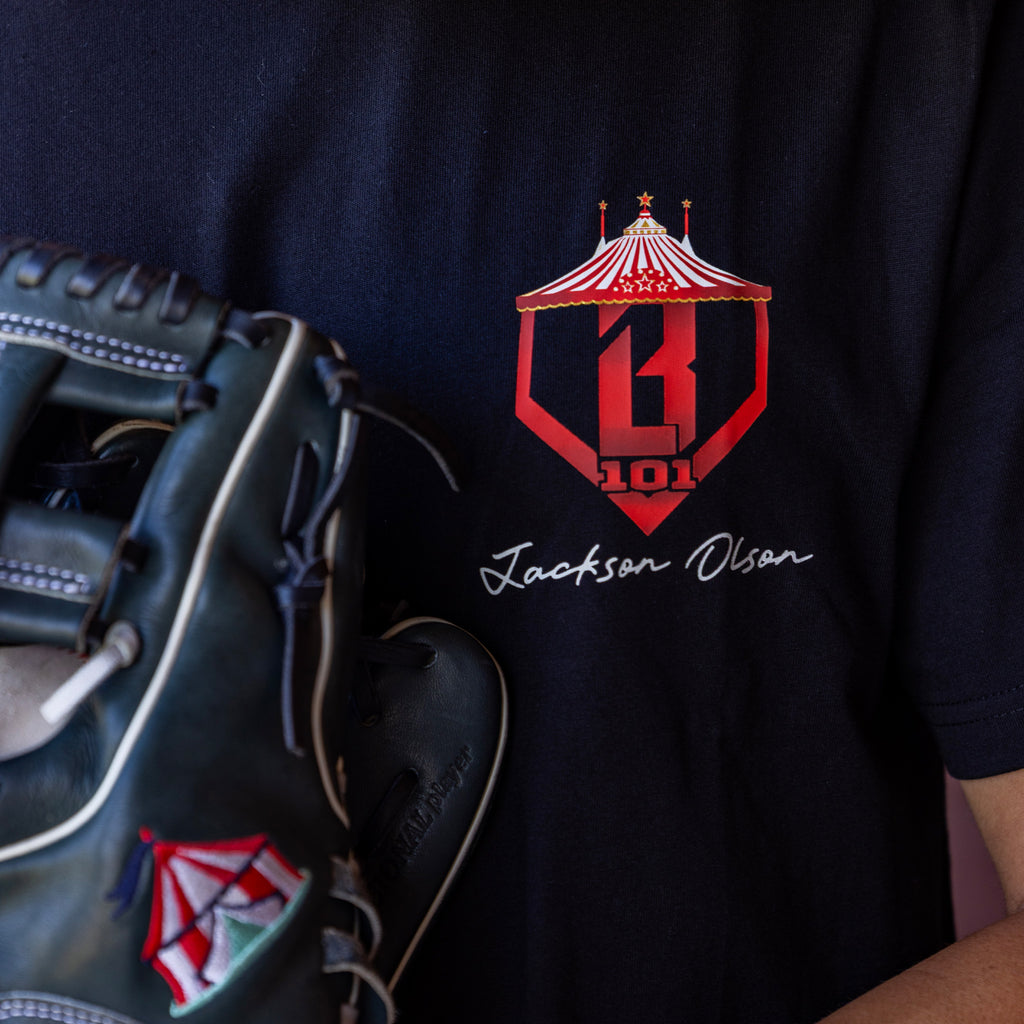 Black t-shirt with red and white BL101 logo and 'Jackson Olson' text, paired with a baseball glove.