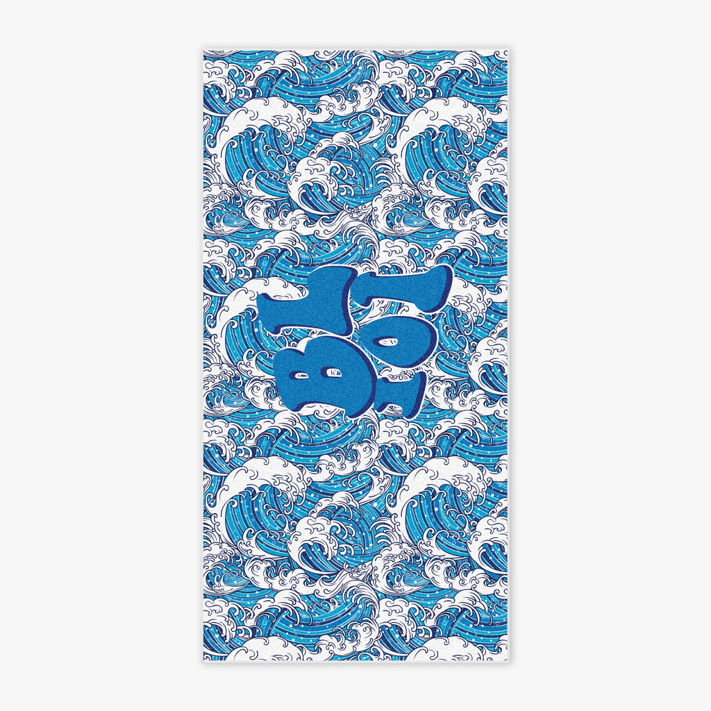 Flat lay of BL101 beach towel featuring an all-over wave pattern and bold center BL101 logo.