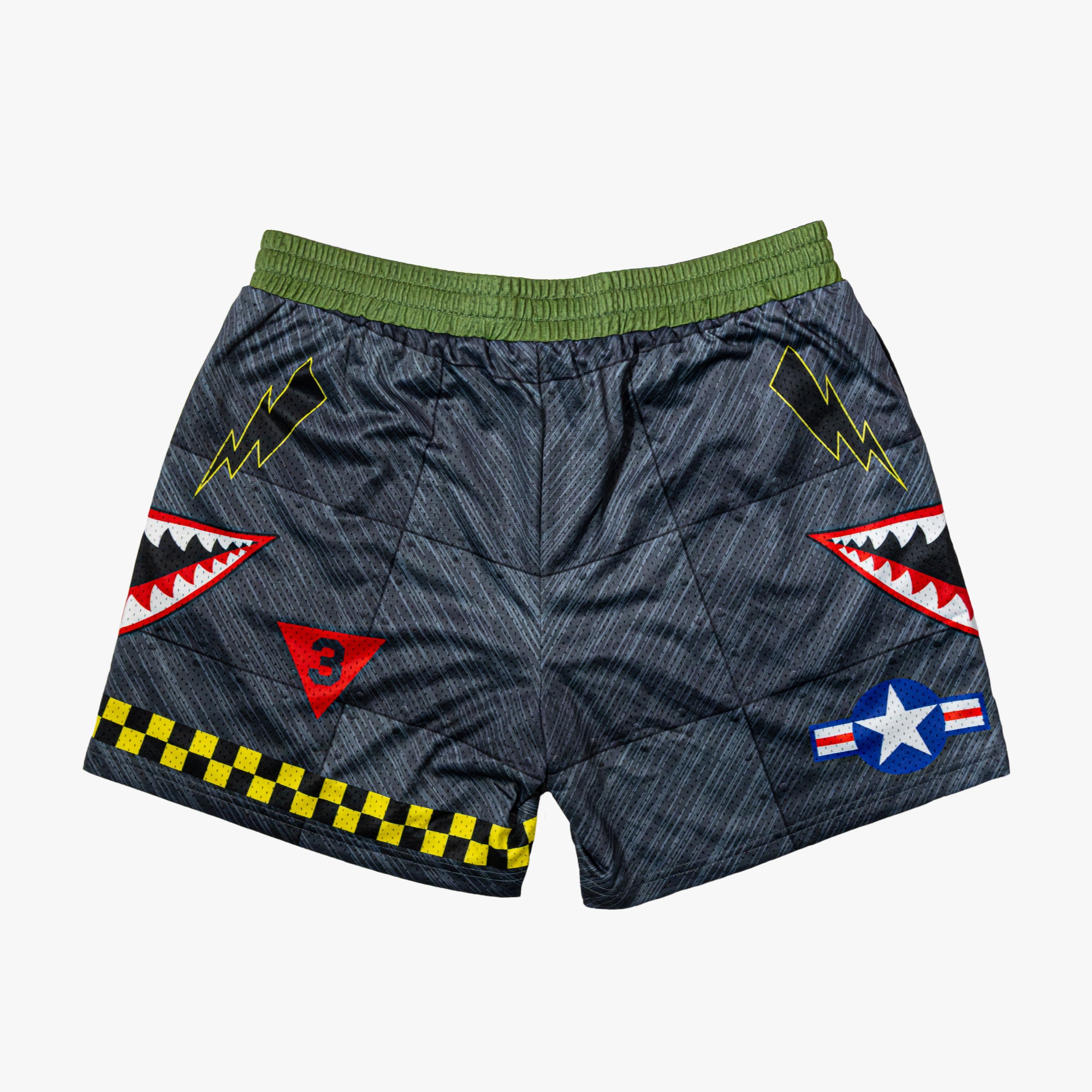 Military-inspired black athletic shorts featuring shark mouth graphics, a white star emblem, black lightening bolts, white BL101 logos on the sides, a green waistband, and yellow checkerboard trim.