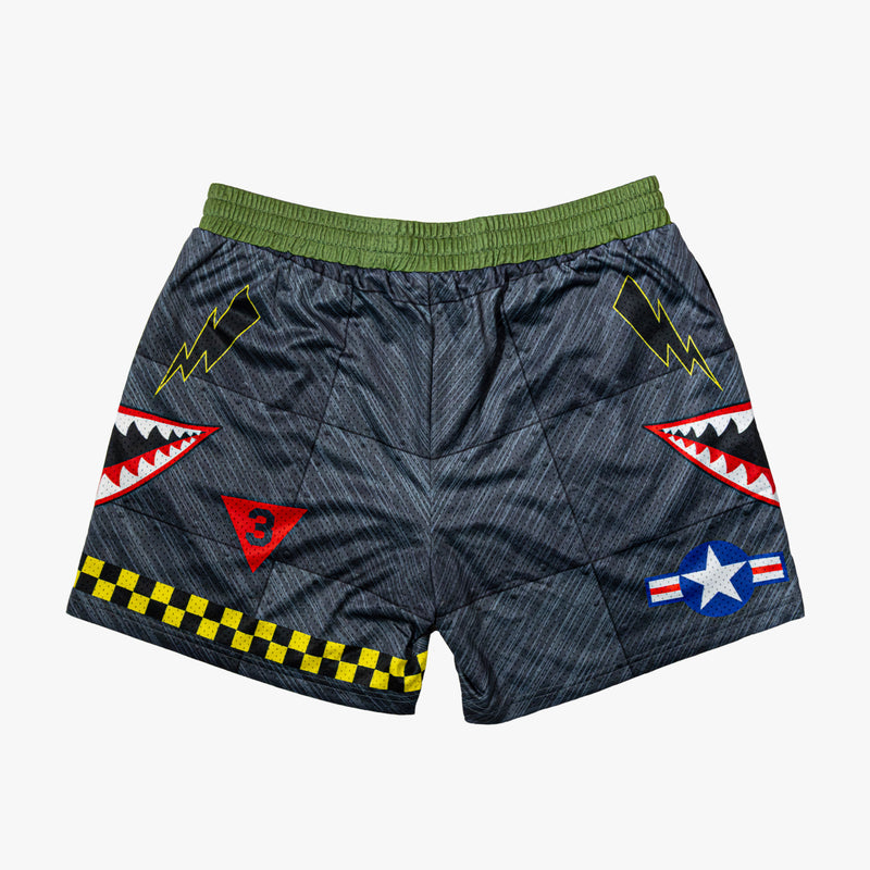 Military-inspired black athletic shorts featuring shark mouth graphics, a white star emblem, black lightening bolts, white BL101 logos on the sides, a green waistband, and yellow checkerboard trim.
