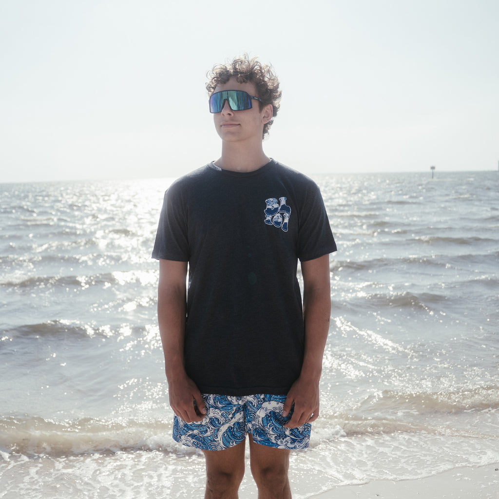 Youth model wearing navy Wave youth graphic tee