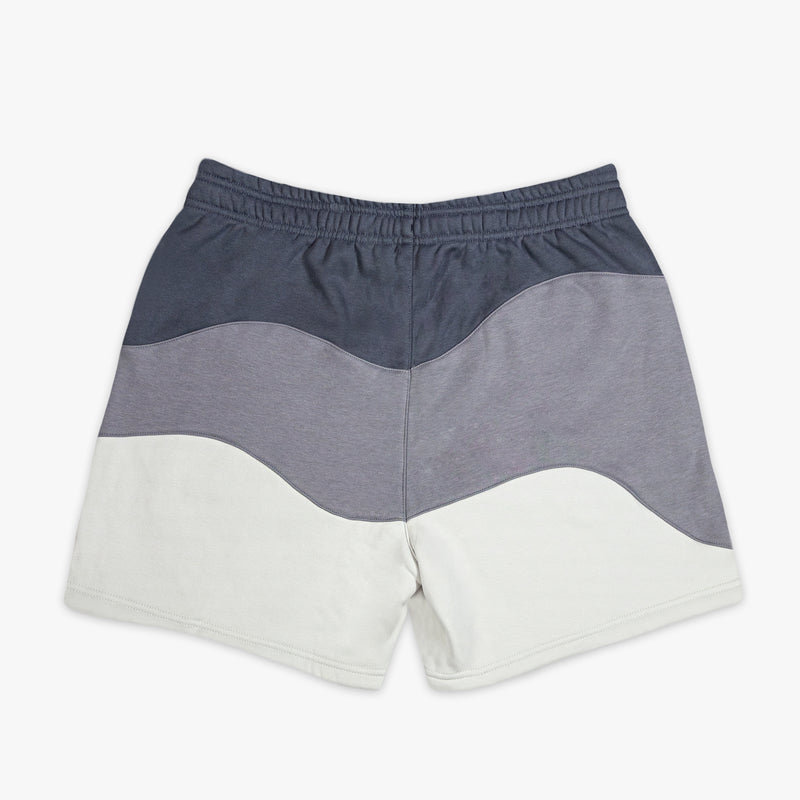 Color-blocked shorts with gray and white sections on a white background