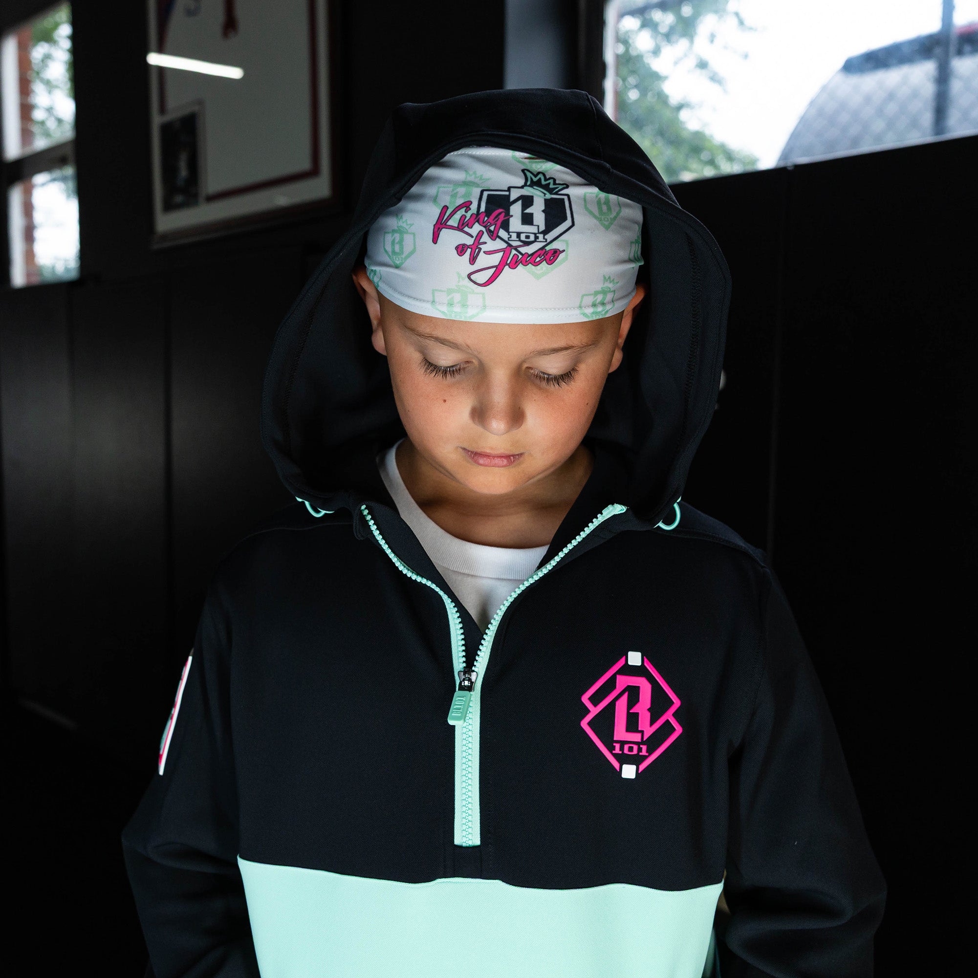 Youth model wearing white headband with "BL101 X Eric Sim" design