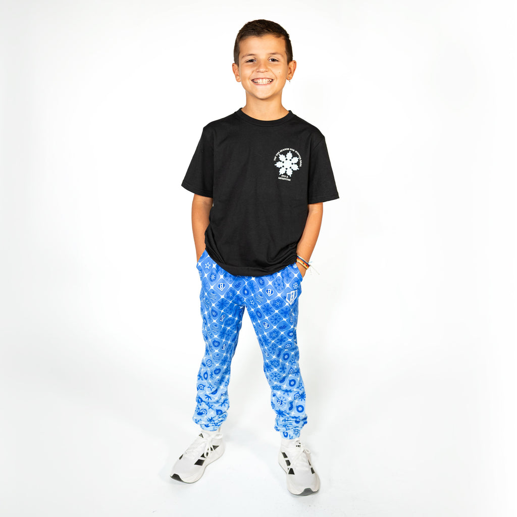 Youth model wearing blue youth pajama pants with "Frozen Diamond" design