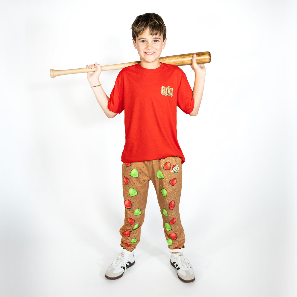 Youth model wearing brown youth pajama pants with "Gingerbread Rookie" design