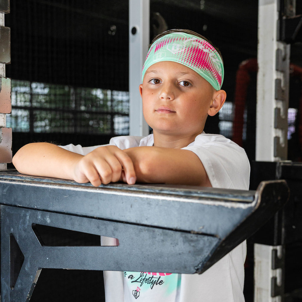 Youth model wearing teal headband with "Hit Tanks" design
