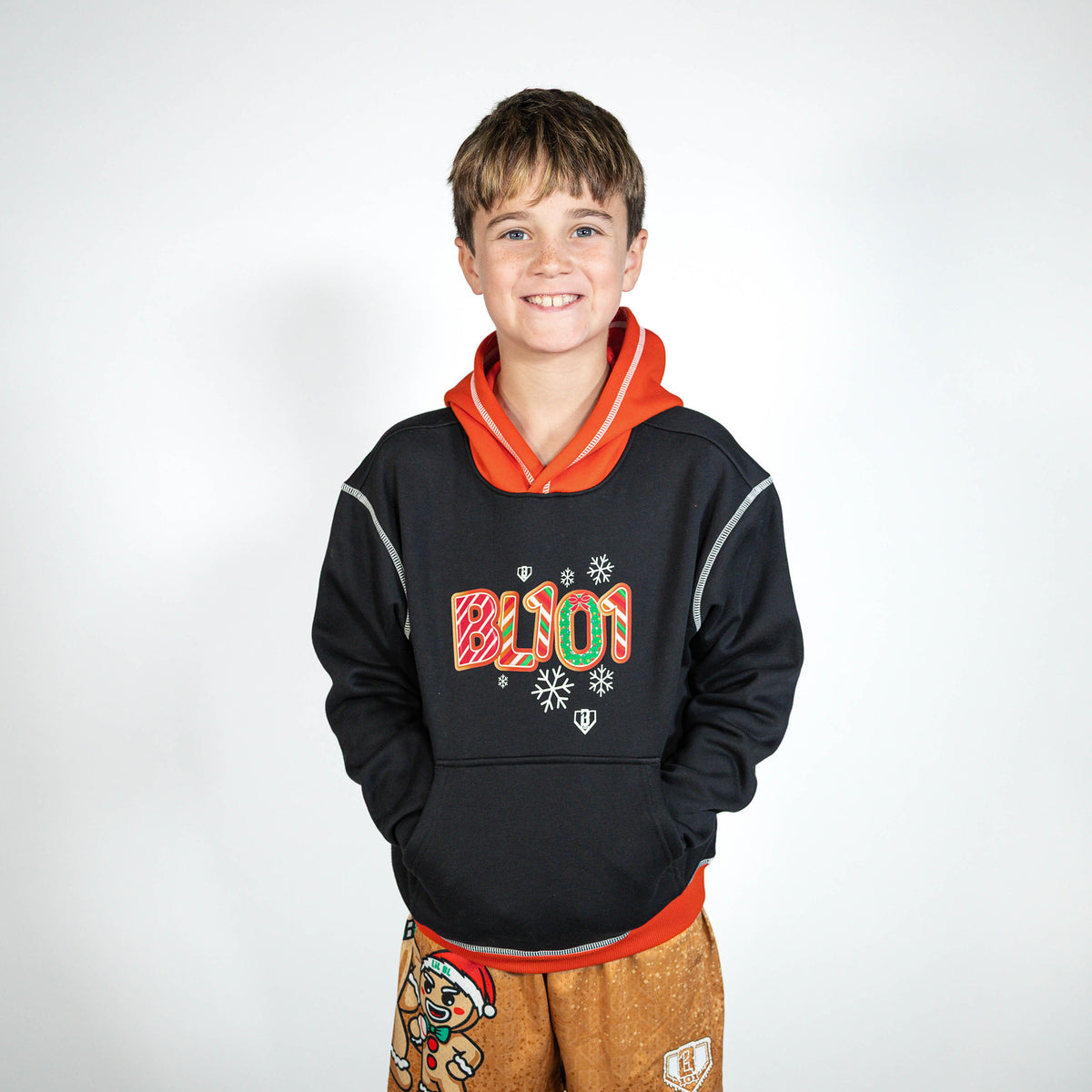 Youth model wearing black youth hoodie with "Holiday Cookie" design