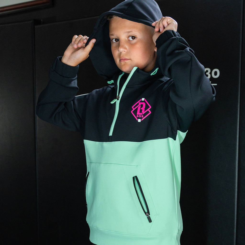 Youth model wearing teal quarter zip hoodie with "King Of JUCO" design