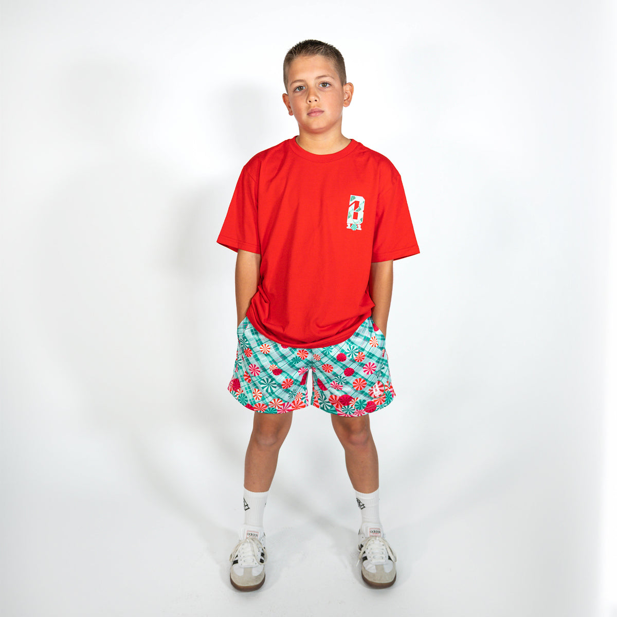 Youth model wearing teal youth shorts with "Peppermint Plaid" design