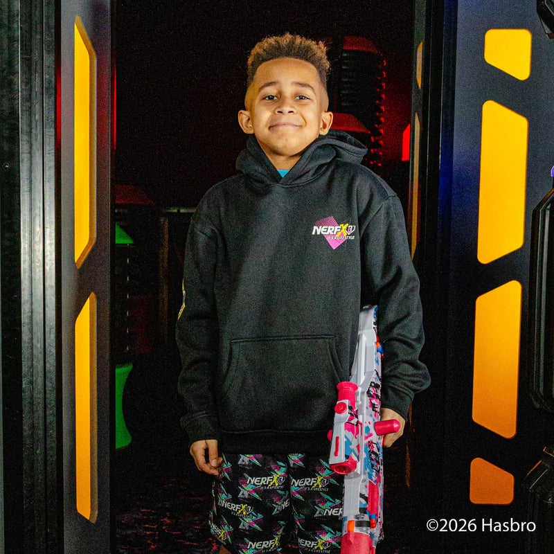 Child wearing a black hoodie with a 'Nerf X BL101' logo, holding a toy, in front of a colorful background.