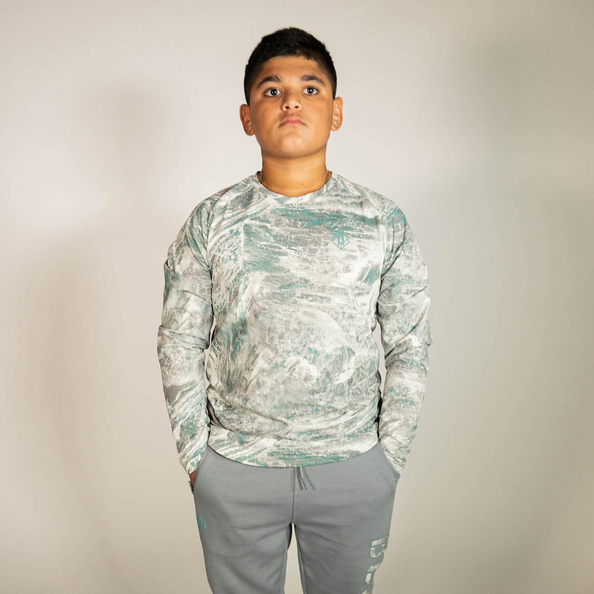 Youth model wearing gray Realtree Aspect Diamond Tech Camo youth long sleeve