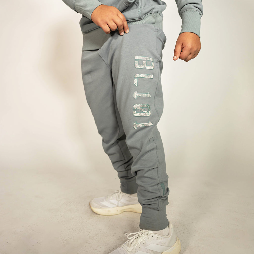 Youth model wearing gray Realtree Aspect Diamond Relaxed Fit Camo youth joggers