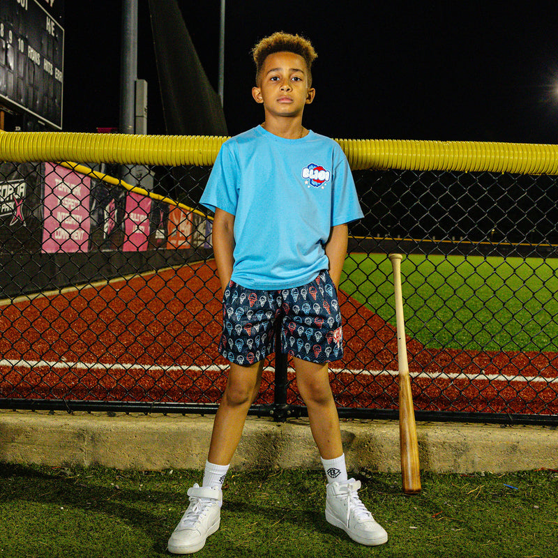 Youth model wearing red, white & blue Scoops Ice Cream youth shorts