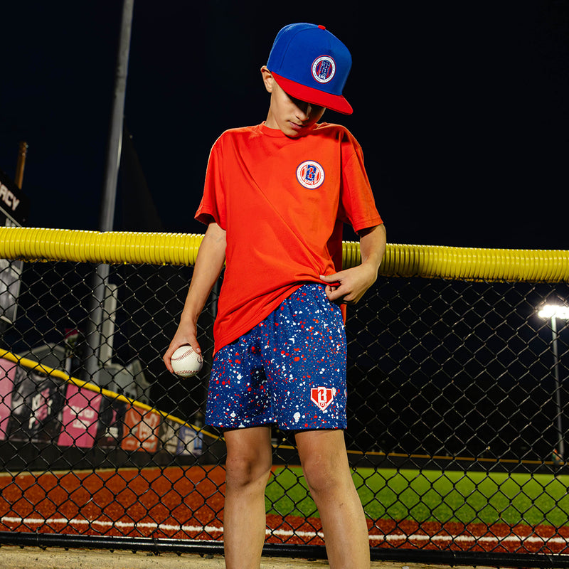 Youth model wearing red, white & blue Splatter USA youth shorts