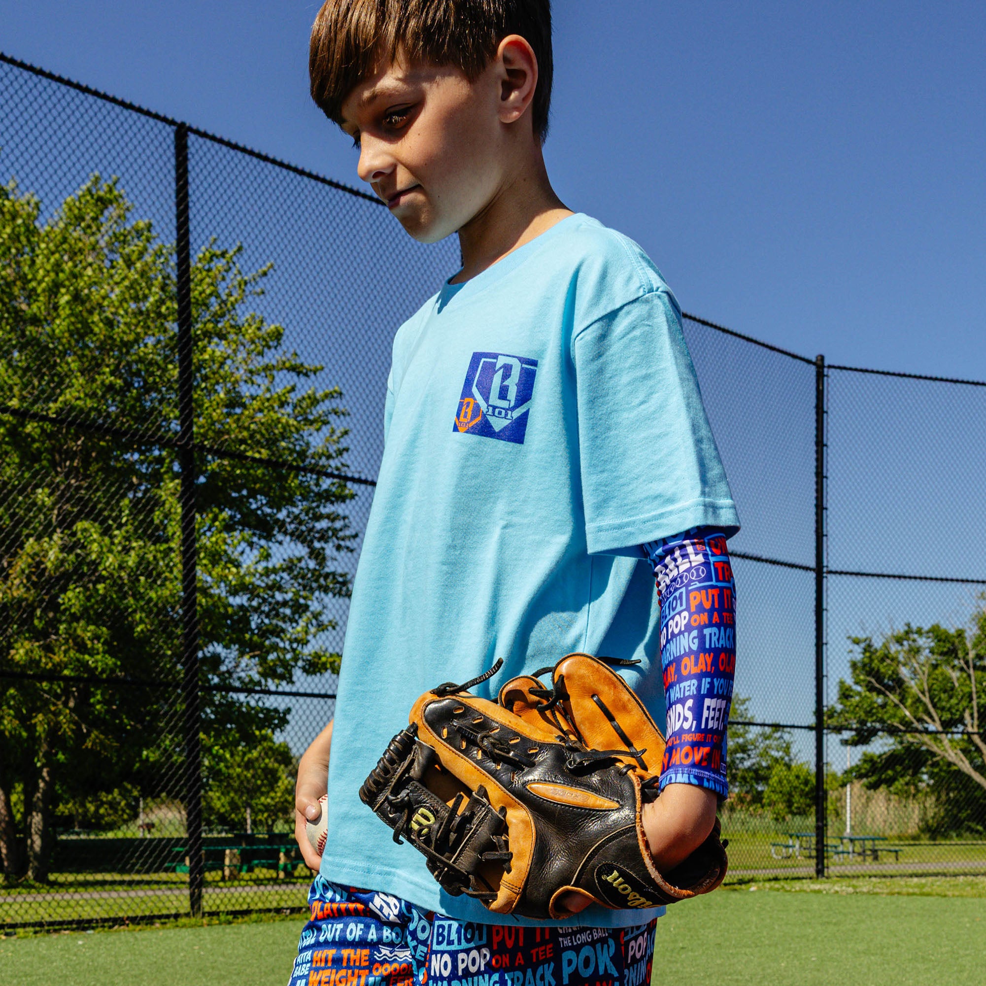Youth model wearing multi-color youth arm sleeve with "Trash Talk Youth" design