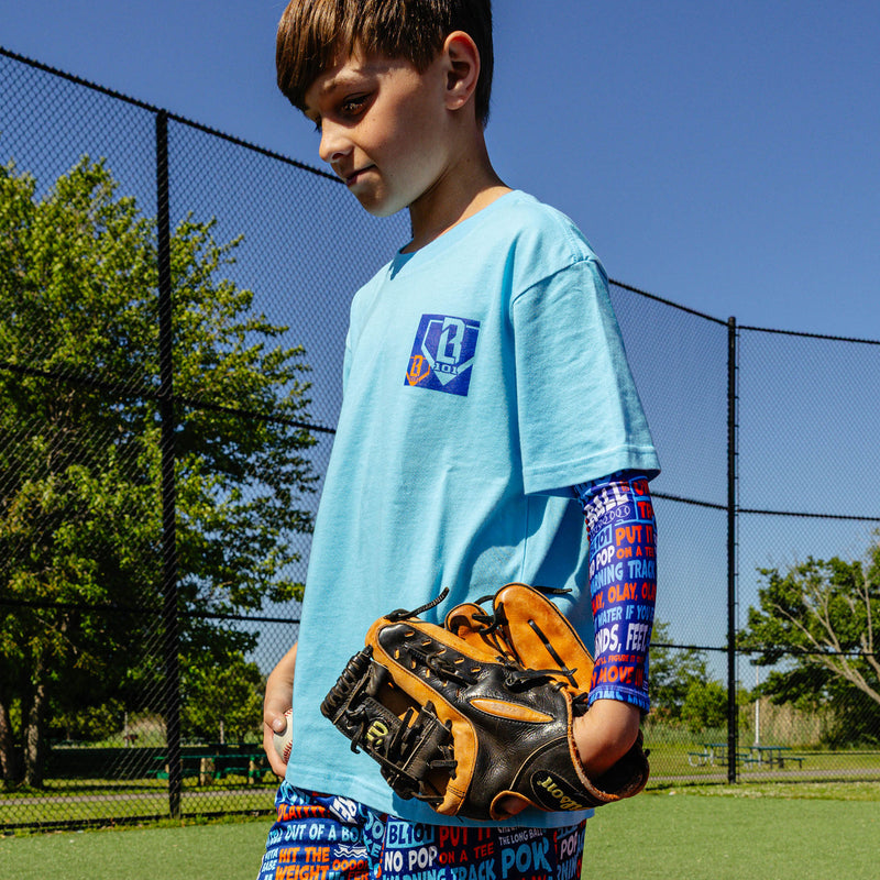 Youth model wearing multi-color youth arm sleeve with "Trash Talk Youth" design