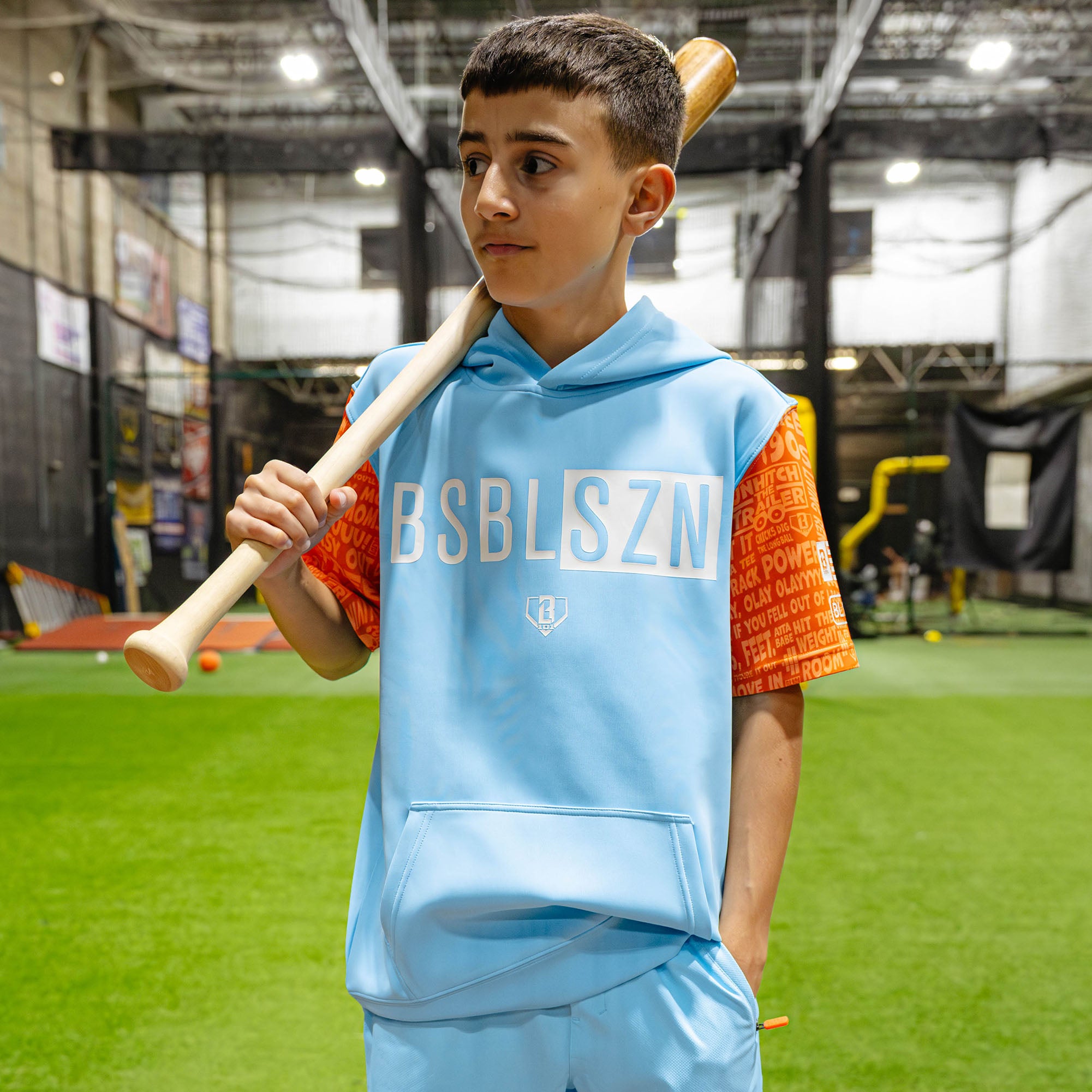 Youth model wearing blue youth short sleeve hoodie with "BSBL-SZN V3 Short Sleeve Youth" design