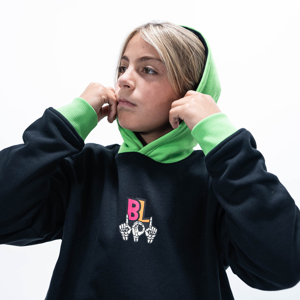 Youth model wearing black youth hoodie with "101 Skeleton" design