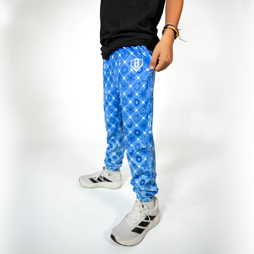 Youth model wearing blue youth pajama pants with "Frozen Diamond" design