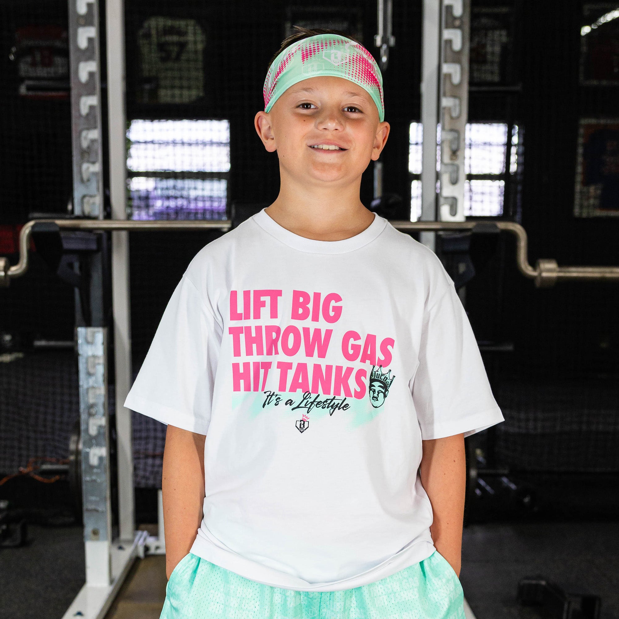 Youth model wearing teal headband with "Hit Tanks" design