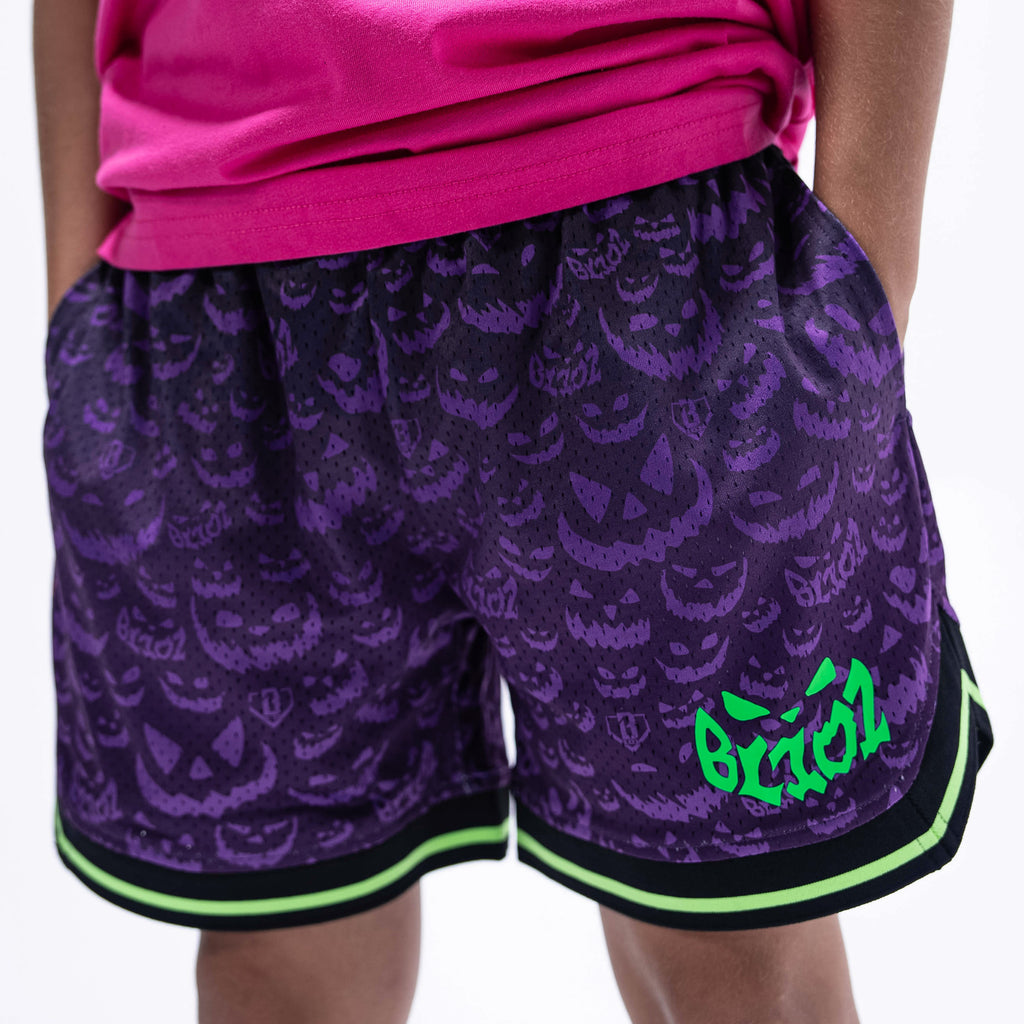 Youth model wearing purple youth shorts with "Jack O' Lantern Team" design