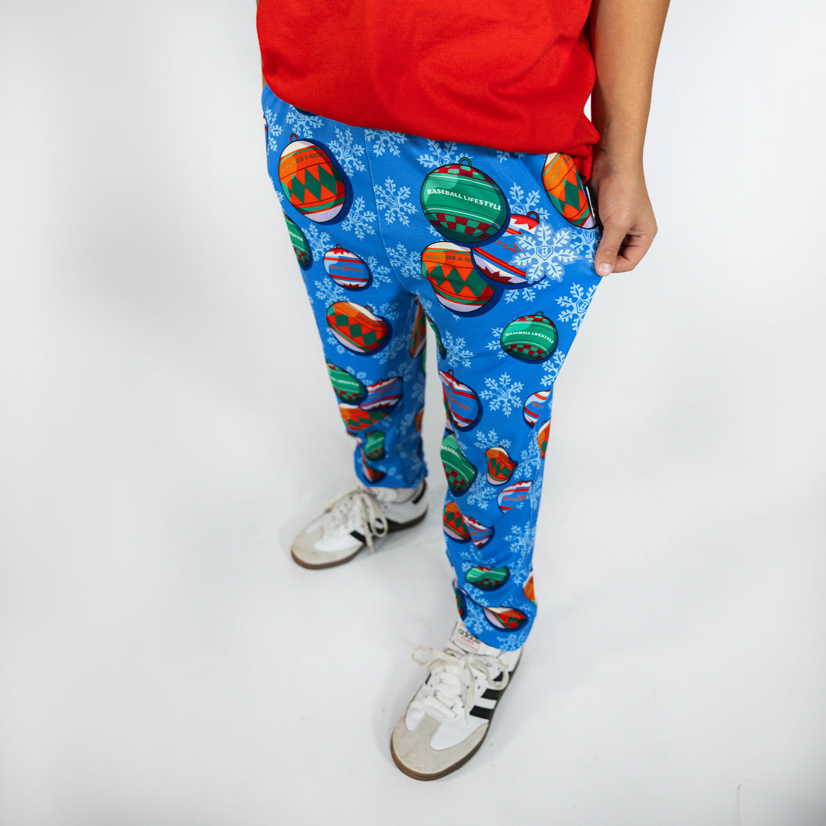 Youth model wearing blue youth pajama pants with "Jingle Ballers" design