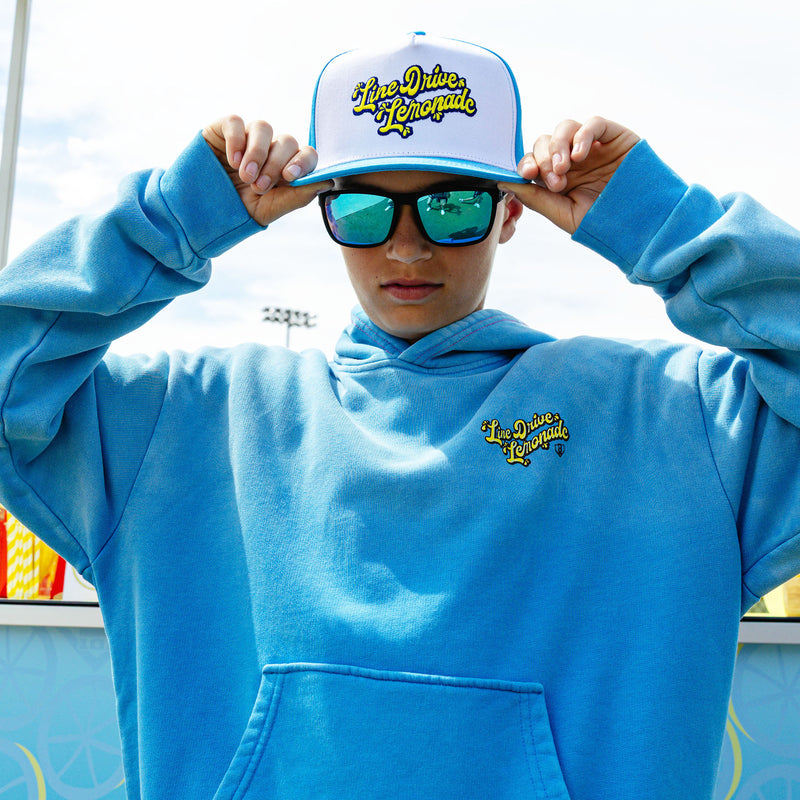 Youth model wearing blue youth hoodie with "Lemonade Cup" design