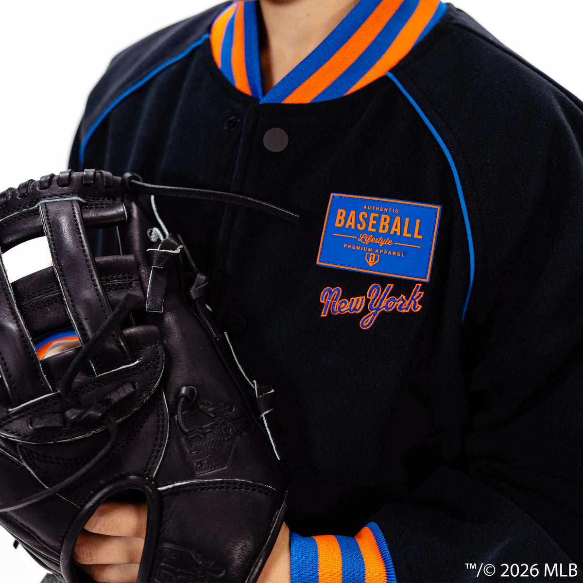 Youth model wearing black New York Mets Stadium youth bomber jacket