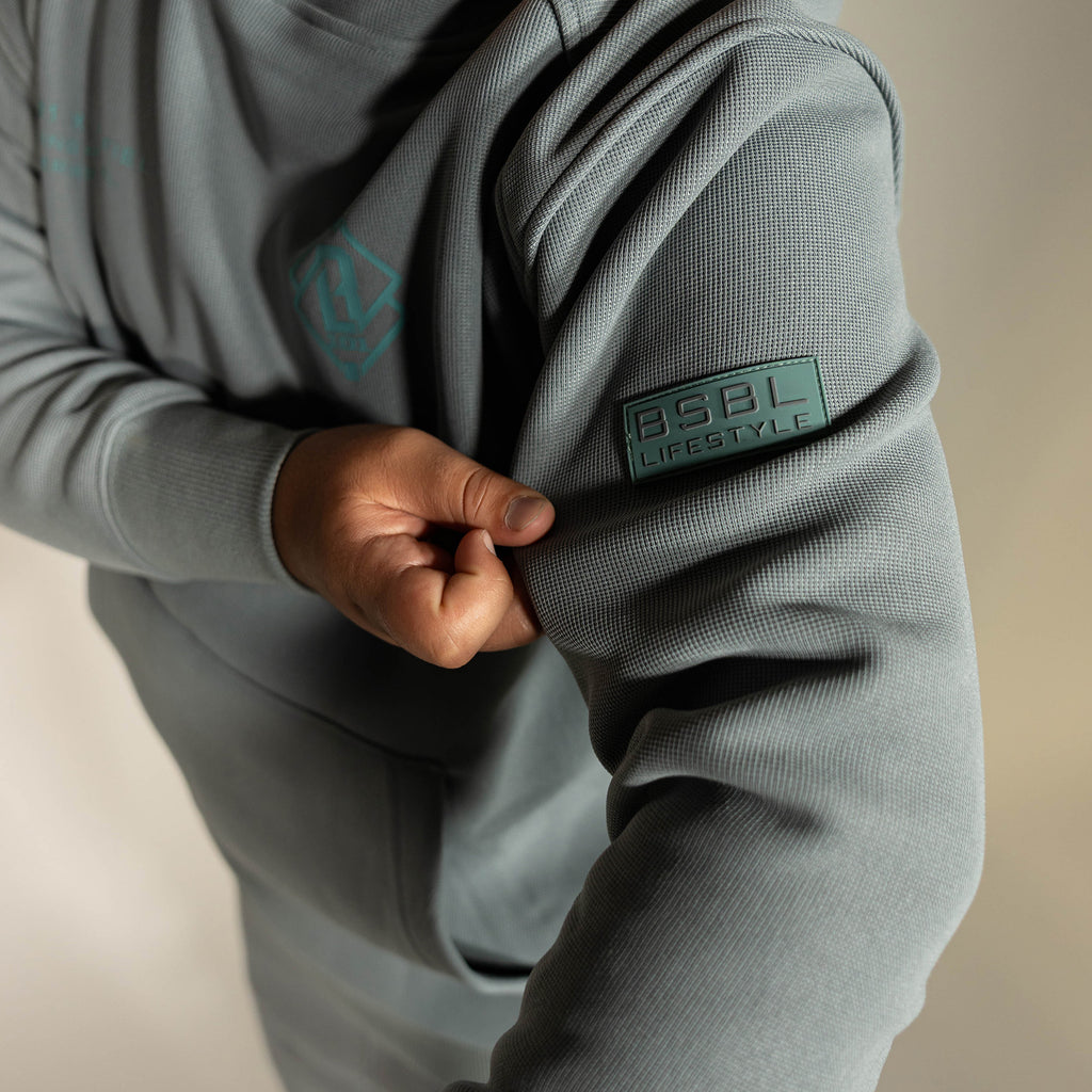 Youth model wearing gray Realtree Aspect Off-Field Waffle Performance Camo youth hoodie